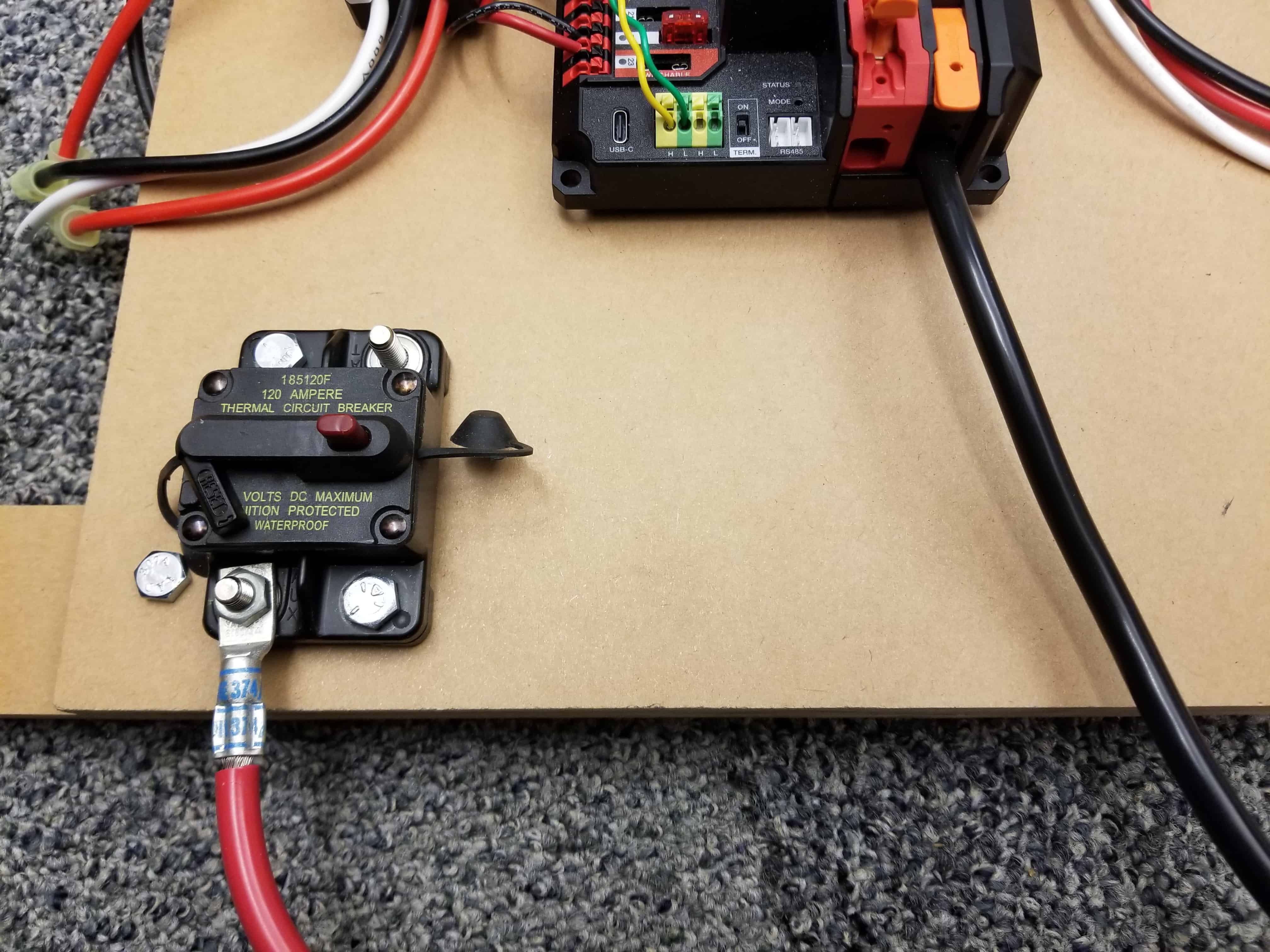 Highlights the location of the terminal lugs on the PDH and circuit breaker.